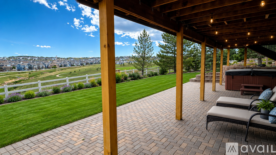 A patio with a view of a green field and trees.