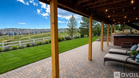 A patio with a view of a green field and trees.