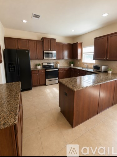 A kitchen with brown cabinets and granite countertops.