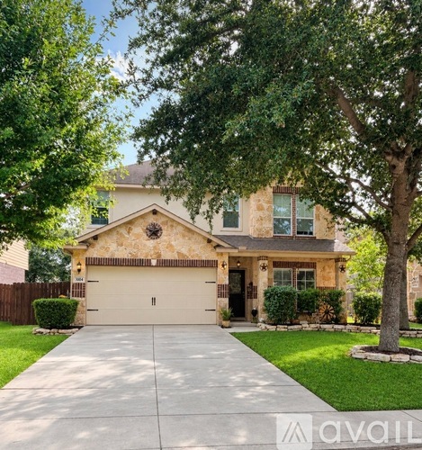 A house with a driveway and a tree in front.