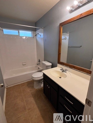 A bathroom with a toilet, sink, and bathtub.