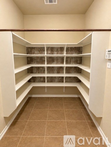 Empty white shelves in a room with brown tiles.