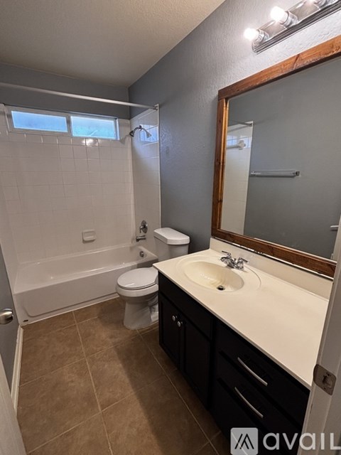 A bathroom with a toilet, sink, and bathtub.