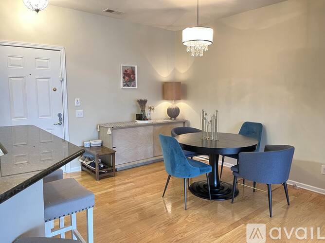 A dining room with a round table and blue chairs.