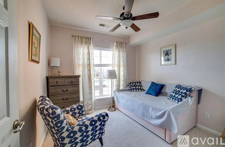 A bedroom with a bed, chair, and dresser.