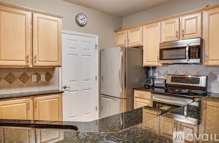 A kitchen with wooden cabinets and a granite countertop.