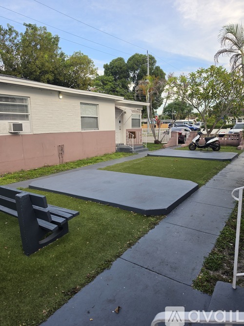 A small, simple backyard with a bench and a trampoline.