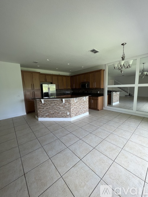 A kitchen with a refrigerator, microwave, and oven is shown.