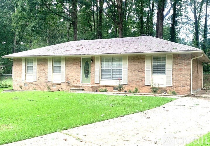 A small house with a green lawn in front.