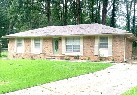 A small house with a green lawn in front.