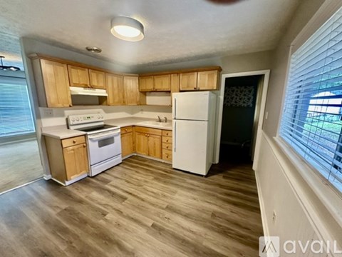 A kitchen with wooden cabinets and a white refrigerator.