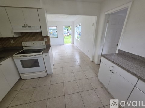 A kitchen with white cabinets and a tiled floor.