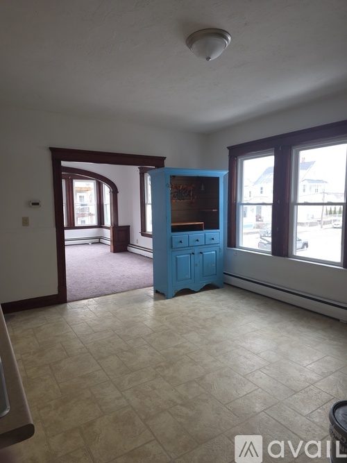 A room with a blue cabinet and a window.