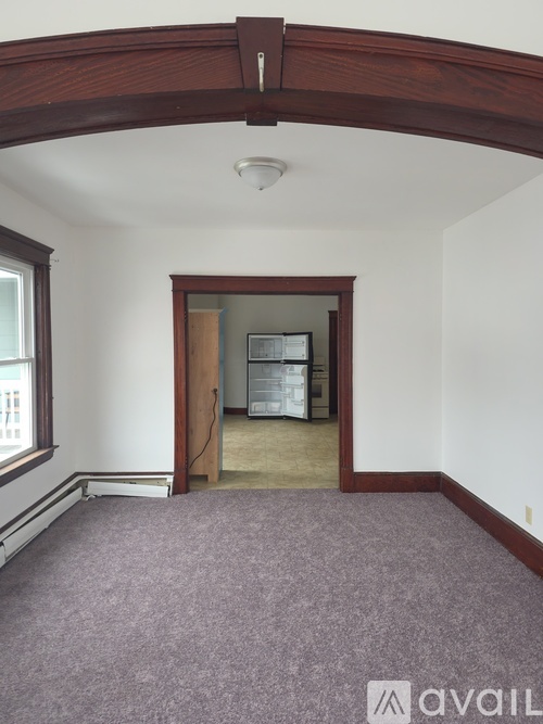 A room with a purple carpet and a wooden archway.