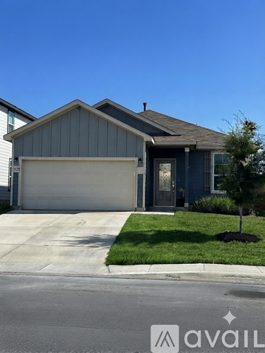 A house with a grey garage door and a brown roof.