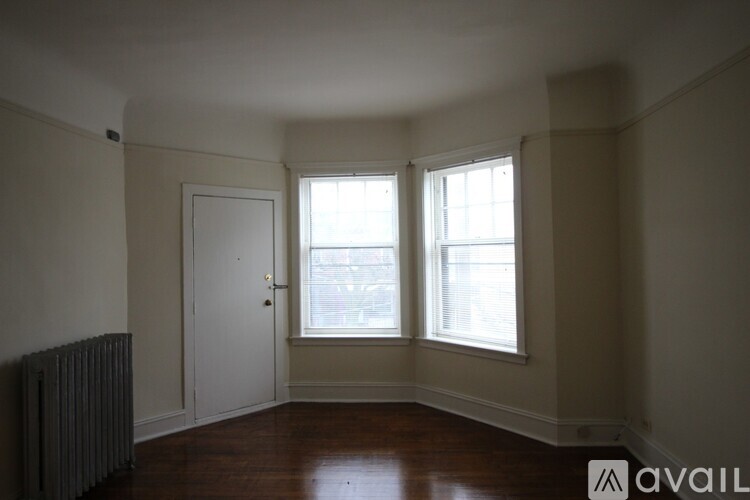 A room with a door, a window, and a radiator.