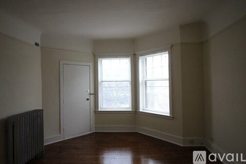 A room with a door, a window, and a radiator.