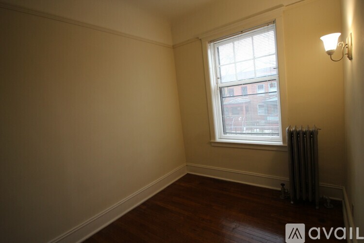 A room with a window and a wall-mounted light fixture.