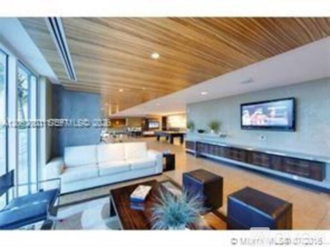 A modern living room with a white sofa and a wooden ceiling.