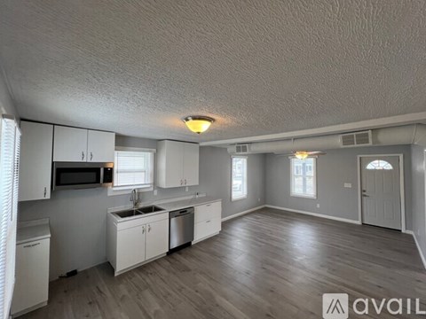 A kitchen with white cabinets and a microwave above the stove.