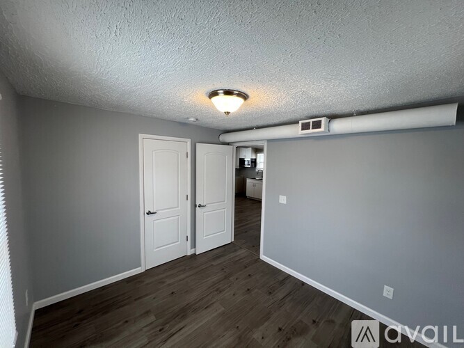 A room with a white ceiling, two doors, and a window.