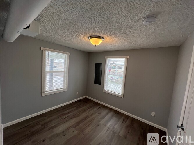 A room with a window and a door is available for rent.
