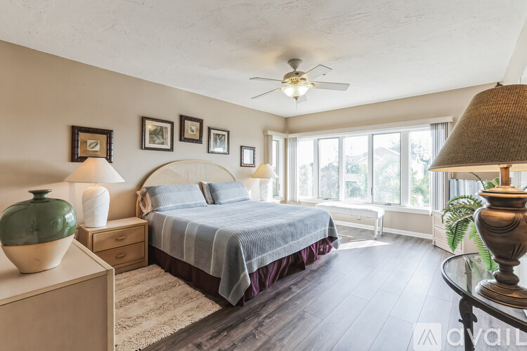 A bedroom with a bed, nightstand, and a ceiling fan.
