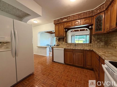 A kitchen with wooden cabinets and a white refrigerator.