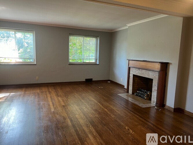 A room with a fireplace and wooden floors.