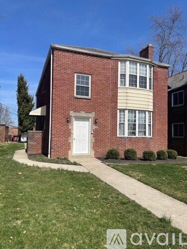 A red brick house with a white door and windows.