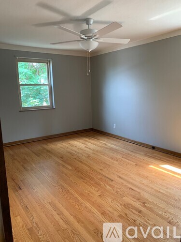 A room with wooden flooring and a ceiling fan.