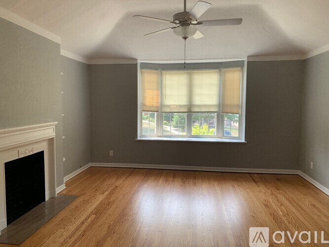 A room with a fireplace and a window with blinds.