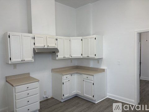 A kitchen with white cabinets and a countertop.