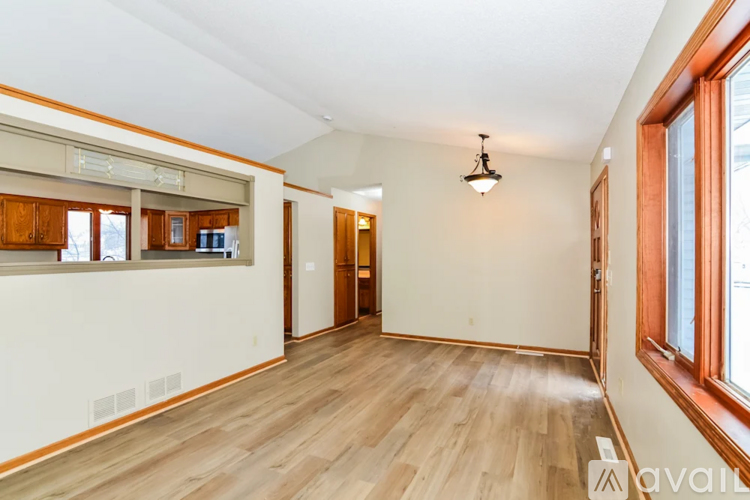 A room with wooden floors and a window on the right side.