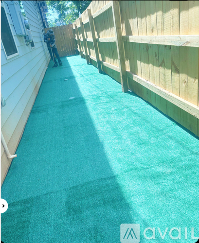 A man is painting a wooden fence.