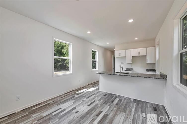 A kitchen with a large island and wooden flooring.