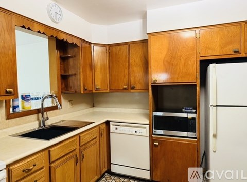 A kitchen with wooden cabinets and a white fridge.