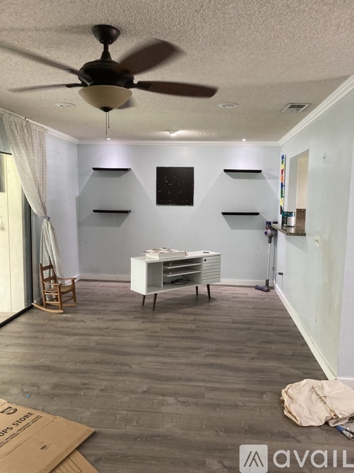 A room with a ceiling fan and a table with chairs.