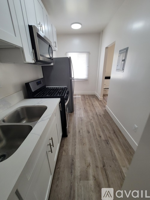 A kitchen with white cabinets and a black stove top oven.