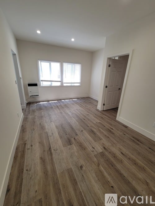 A room with wooden flooring and a window.