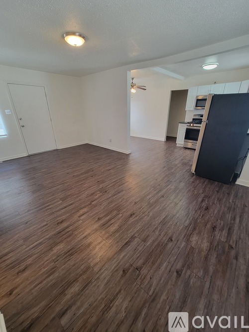 A room with wooden flooring and a ceiling fan.