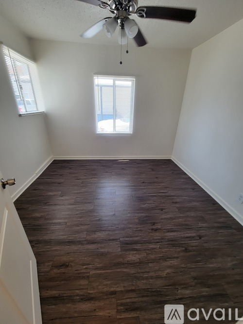 A room with wooden flooring and a ceiling fan.
