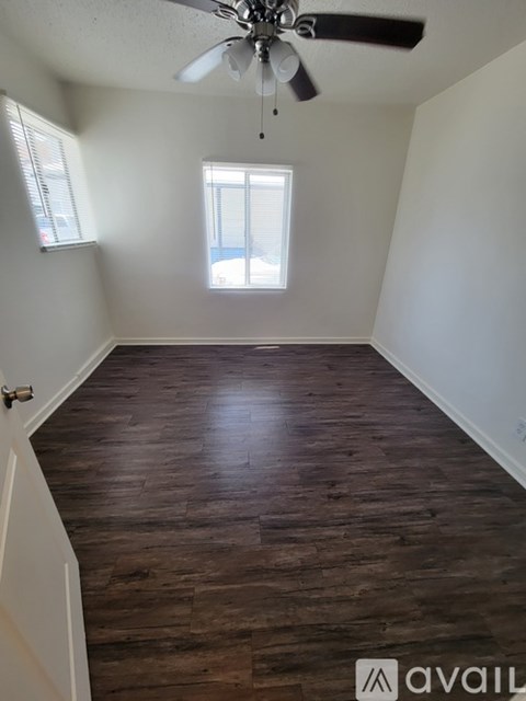 A room with wooden flooring and a ceiling fan.
