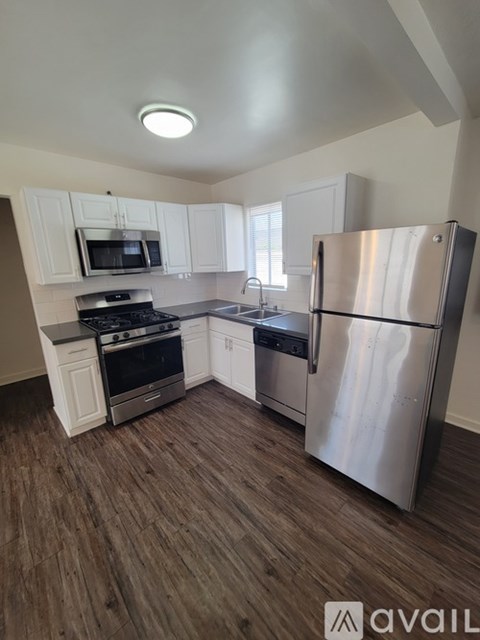 A kitchen with a refrigerator, stove, and microwave.