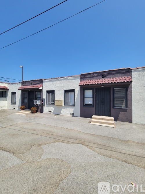 A building with a red tile roof and a sign that says "avail" in front of it.