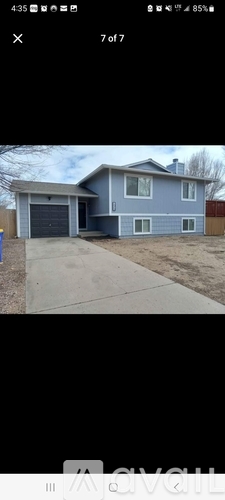 A house with a grey exterior and a white garage door.