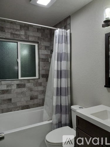 A bathroom with a toilet, sink, and shower curtain.