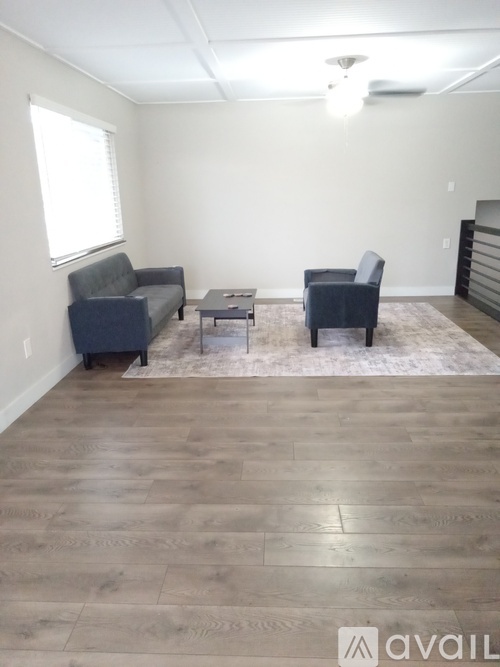 A living room with a grey couch, a chair, and a coffee table.