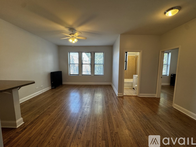 A room with wooden floors and a ceiling fan.