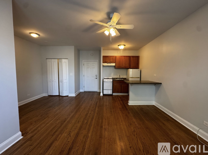 A room with wooden floors and a ceiling fan.